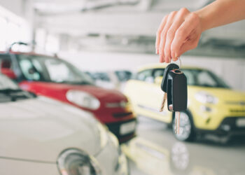 Primer plano de un concesionario de automóviles que sostiene las llaves del coche a la cámara