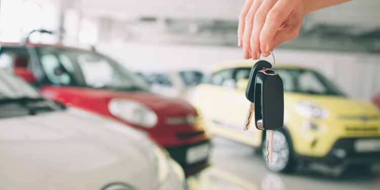 Primer plano de un concesionario de automóviles que sostiene las llaves del coche a la cámara