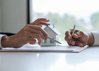 Agente inmobiliario explica el proceso hipotecario al cliente.