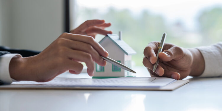 Agente inmobiliario explica el proceso hipotecario al cliente.